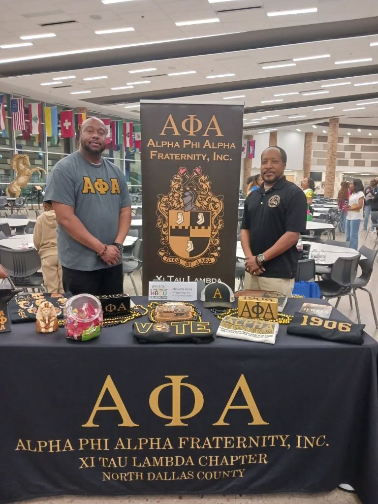Xi Tau Lambda Chapter brothers at an Alpha Phi Alpha community outreach table, North Dallas County