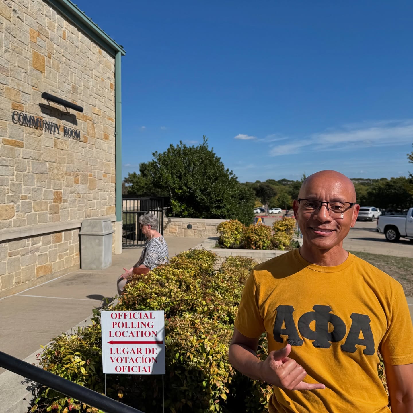 Xi Tau Lambda brother in Alpha Phi Alpha gear standing at an official polling location in North Dallas